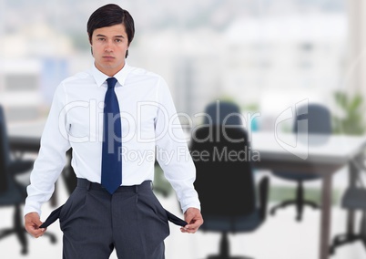 Sad businessman with empty pockets against office background