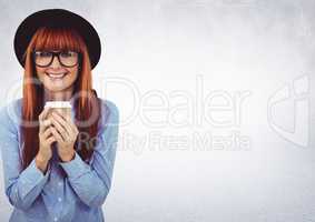 Woman in hat with coffee cup against white wall