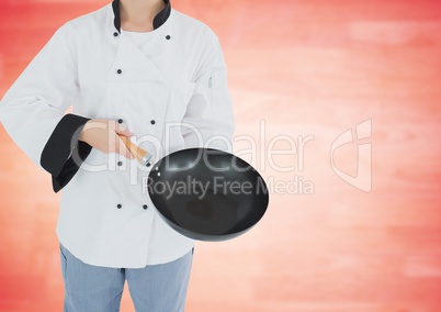 Chef with wok against blurry red wood panel