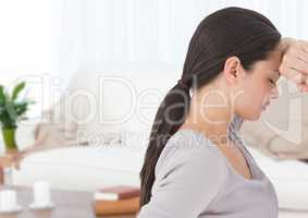 Sad woman leaning on wall at home