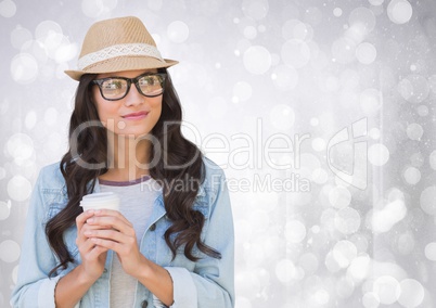 Woman in fedora with white coffee cup against white bokeh