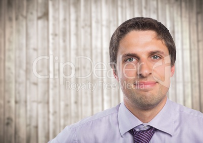 Close up of man in lavendar shirt against blurry wood panel