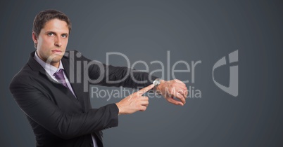 Business man looking at watch against grey background