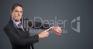 Business man looking at watch against grey background