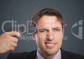 Close up of business man with gun to head against grey background