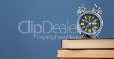 Pile of books with clock against blue background