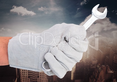 Mechanic hand with wrench against blurry skyline