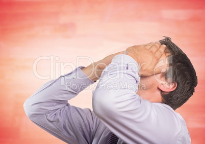Man in lavendar shirt covering face against blurry red wood panel