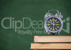 Pile of books with clock against green chalkboard