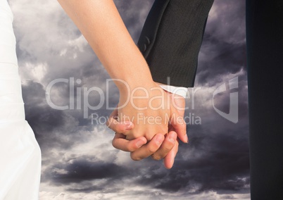 Wedding couple holding hands by bed