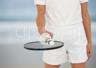Badminton player mid section on blurry beach