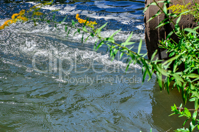 Water flows from the pipe into the river.