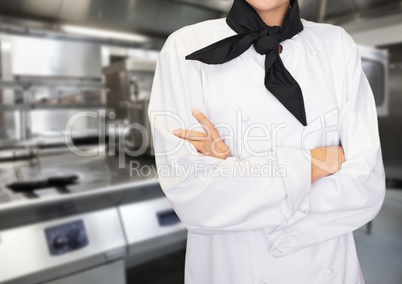 Chef arms folded against blurry kitchen