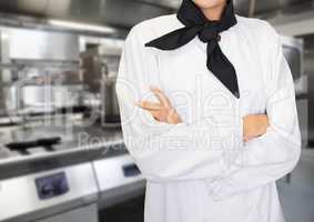 Chef arms folded against blurry kitchen