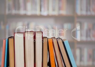 Standing books against blurry bookshelf