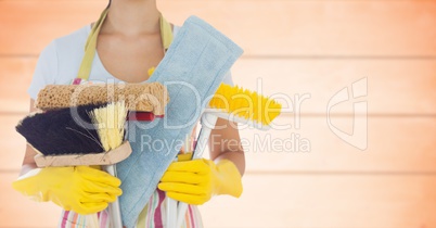 Woman in apron with brushes against blurry orange wood panel