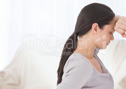 Sad tired woman leaning on wall against sheets