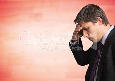 Business man portrait with hand on forehead against blurry red wood panel