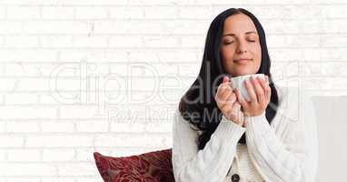 Woman on couch with white mug against white brick wall