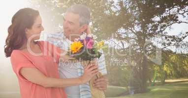 Couple with flowers in park with bright light