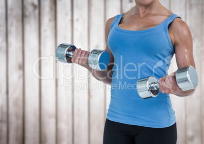 Woman weightlifting against blurry wood panel