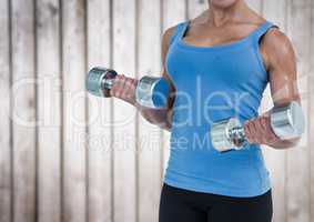 Woman weightlifting against blurry wood panel