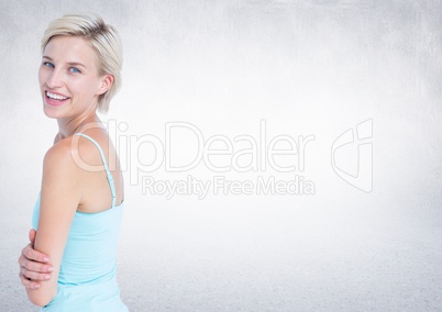 Woman arms folded looking over shoulder against white wall