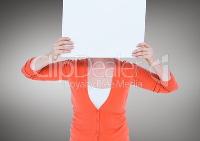 Woman in orange cardigan with blank card over face against grey background