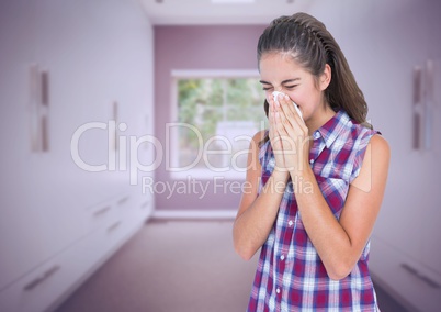 Girl blowing her nose in tissue in long room
