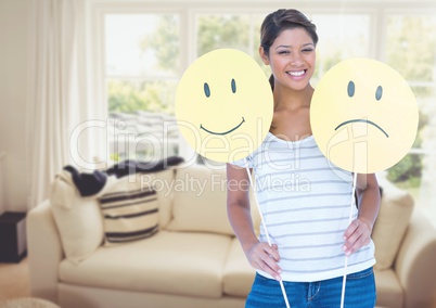 Woman holding happy or sad faces in sitting room