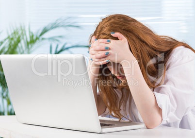 Stressed woman on laptop desk in office