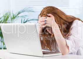 Stressed woman on laptop desk in office