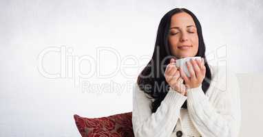 Woman on couch with white mug against white wall