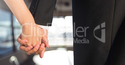 Wedding couple holding hands near windows