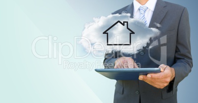 Business man with tablet and cloud with house against blue background