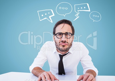 Man at desk with white speech bubbles against blue background