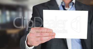Business man mid section with blank card in blurry room