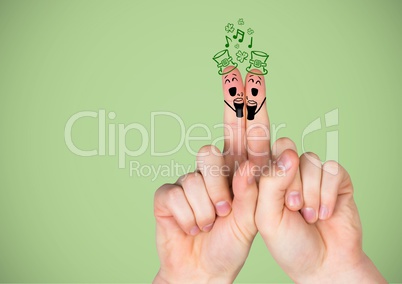 Hands with patrick's day faces drawn on against green background