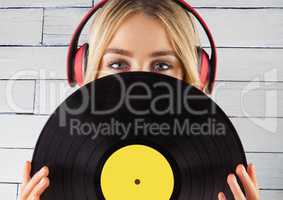 Woman with headphones and record against white panel