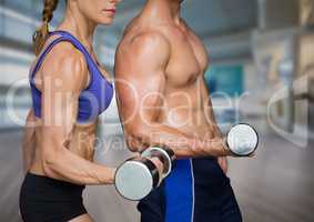Man and Woman mid sections weightlifting in blurry gym