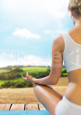 Woman Meditating by green hills