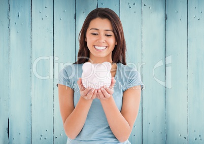 Woman with piggy bank against blue wood panel