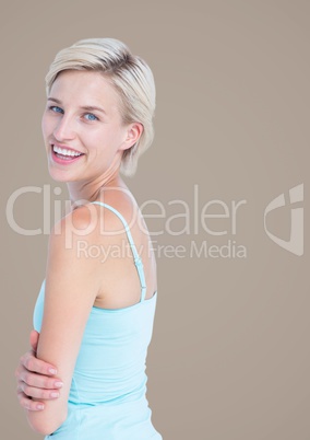 Woman arms folded looking over shoulder against brown background