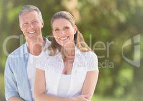 Couple smiling against blurry green background