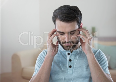 Stressed man on headphones relaxing at home