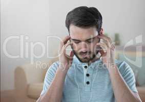 Stressed man on headphones relaxing at home