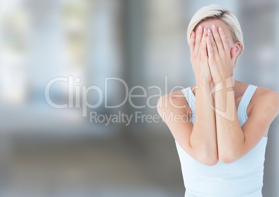 Sad woman grief with face in hands against blurred street