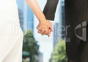 Wedding couple holding hands in city