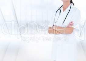 Doctor mid section with arms folded against blurry window