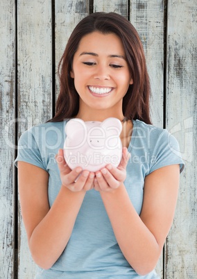 Woman with piggy pank against wood panel